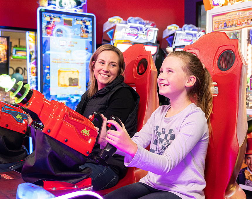 Mother and daughter playing arcade games at Sunset Superbowl